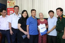 Phó Tổng Giám đốc TTXVN Đinh Đăng Quang tặng quà cho hộ gia đình thương binh, liệt sỹ, người có công trên địa bàn thành phố Hà Giang. (Nguồn: TTXVN)