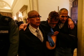 Hỗ trợ một nghị sỹ Quốc hội Venezuela bị thương trong vụ tấn công. (Nguồn: EPA/TTXVN)