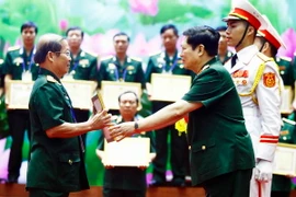 Đại tướng Ngô Xuân Lịch trao tặng Bằng khen cho các cá nhân, vì đã có nhiều thành tích trong công tác góp phần vào xây dựng sự nghiệp quân đội, củng cố quốc phòng và bảo vệ Tổ quốc. (Ảnh: An Đăng/TTXVN)