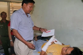 Ông Phạm Văn Nam, Phó Chủ tịch Ủy ban Nhân dân tỉnh Bình Thuận thăm hỏi, hỗ trợ chiến sỹ công an bị thương. (Ảnh: Nguyễn Thanh/TTXVN)