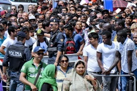 Người di cư xếp hàng chờ được cấp giấy phép cư trú tại trụ sở cảnh sát ở Naples, miền nam Italy. (Nguồn: EPA/TTXVN)