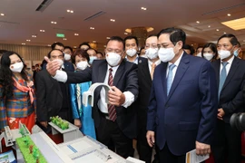 Thủ tướng Phạm Minh Chính và các đại biểu tham quan trưng bày các sản phẩm ứng dụng công nghệ sáng tạo. (Ảnh: Dương Giang/TTXVN) 