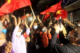 Người dân Lô 112 khu tập thể Công nhân Dư Hàng vui mừng khi được thực hiện gỡ bỏ lệnh phong tỏa. (Ảnh: An Đăng/TTXVN)