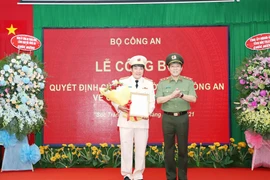 Trung tướng Lương Tam Quang trao quyết định và tặng hoa chúc mừng Đại tá Lâm Thành Sol, tân Giám Đốc Công an Sóc Trăng. (Ảnh: TTXVN phát)