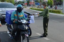 Người giao nhận hàng hóa thiết yếu khi đi qua chốt kiểm soát phải trình Thẻ nhận diện phương tiện do Sở Giao thông vận tải thành phố Đà Nẵng cấp. (Ảnh: Quốc Dũng/TTXVN)