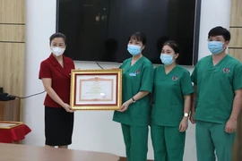 Phó Bí thư Thường trực tỉnh ủy Bắc Giang Lê Thị Thu Hồng trao Bằng khen của Thủ tướng chính phủ cho tập thể Bệnh viện Việt Nam-Thụy Điển Uông Bí (Quảng Ninh). (Ảnh: Danh Lam/TTXVN) 
