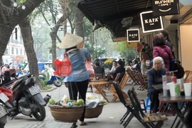 Dù chiếm dụng nhiều hay ít diện tích vỉa hè thì việc các quán càphê lấn chiếm vỉa hè phố Lý Thường Kiệt, quận Hoàn Kiếm như thế này đều là vi phạm pháp luật, phải bị xử phạt (ảnh chụp chiều 24/3/2021). (Ảnh: Phan Tuấn Anh/TTXVN)