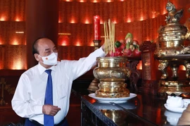 Chủ tịch nước Nguyễn Xuân Phúc dâng hương tưởng niệm các Anh hùng liệt sỹ tại Đền Tưởng niệm Liệt sỹ Bến Dược. (Ảnh: Thống Nhất/TTXVN) 