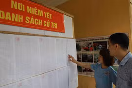 Người dân xem danh sách cử tri. (Nguồn: TTXVN)