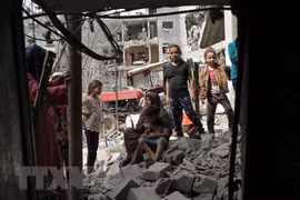 Người dân Palestine trở về bên những căn nhà đã bị phá hủy trong các cuộc không kích của máy bay Israel xuống thị trấn Beit Hanoun, Dải Gaza, khi lệnh ngừng bắn có hiệu lực. (Ảnh: THX/TTXVN) 
