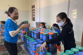 Người dân thị xã Cửa Lò (Nghệ An) chế biến cá khô rim cùng lạc rang, đóng thành hộp để hỗ trợ người dân Thành phố Hồ Chí Minh chống dịch COVID-19. (Ảnh: Tá Chuyên/TTXVN) 