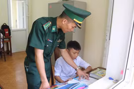 Chiến sỹ Đồn Biên phòng Pa Thơm (Bộ đội Biên phòng tỉnh Điện Biên) trực tiếp tiếp kèm cặp, hỗ trợ các cháu con nuôi của đơn vị học tập hằng ngày trong góc học tập riêng của các cháu. (Ảnh: Xuân Tiến/TTXVN)