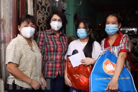 Chủ tịch Ủy ban MTTQ Thành phố Hồ Chí Minh Tô Thị Bích Châu thăm hỏi và tặng quà cho các em mồ côi vì COVID-19 tại quận 4. (Ảnh: Thu Hương/TTXVN) 