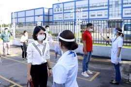 Công nhân và khách vào làm việc tại công ty TNHH Optrontec Vina (khu công nghiệp Bá Thiện 2-Vĩnh Phúc) được kiểm tra thân nhiệt. (Ảnh: TTXVN) 