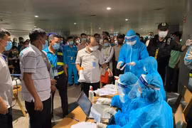 Nhân viên y tế làm thủ tục lấy mẫu xét nghiệm cho người làm việc tại sân bay Tân Sơn Nhất, ngày 6/2. (Ảnh: TTXVN phát)