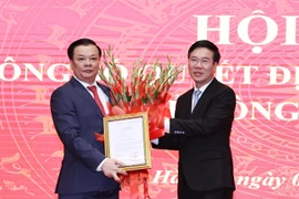 Ông Võ Văn Thưởng, Ủy viên Bộ Chính trị, Thường trực Ban Bí thư trao Quyết định của Bộ Chính trị phân công ông Đinh Tiến Dũng giữ chức Bí thư Thành ủy Hà Nội. (Ảnh: Văn Điệp/TTXVN)