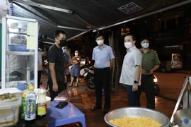 Đoàn kiểm tra, nhắc nhở quán phở trên phố Đền Lừ 2, phường Hoàng Văn Thụ, quận Hoàng Mai mở cửa sau 21 giờ. (Ảnh: Minh Quyết/TTXVN)