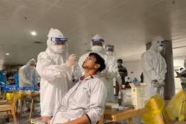 Nhân viên y tế lấy mẫu xét nghiệm cho người làm việc tại sân bay Tân Sơn Nhất. (Nguồn: TTXVN phát)