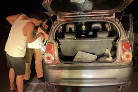 Các chiến sỹ của Đội tuần tra kiểm soát cao tốc số 1 giúp đỡ một lái xe đi mua xăng do xe đang lưu thông trên cao tốc Nội Bài-Lào Cai bị hết xăng. (Ảnh: TTXVN phát)