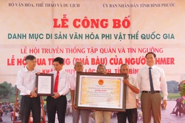 Đại diện địa phương nhận quyết định công nhận Lễ hội Phá Bàu là di sản văn hóa phí vật thể quốc gia. (Ảnh: K GỬIH/TTXVN)