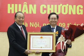 Phó Thủ tướng Thường trực Trương Hòa Bình trao tặng Huân chương Độc lập hạng Nhì cho Nguyên Bộ trưởng Bộ Nội vụ Lê Vĩnh Tân. (Ảnh: Văn Điệp/TTXVN)