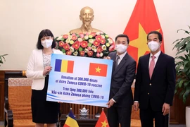 Thứ trưởng Bộ Ngoại giao Tô Anh Dũng và Thứ trưởng Bộ Y tế Trần Văn Thuấn đón nhận tượng trưng 300.000 liều vaccine COVID-19 từ Đại sứ Romania tại Việt Nam Cristina Romila. (Ảnh: Lâm Khánh/TTXVN)