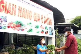 Người dân Đồng Nai bị ảnh hưởng do dịch COVID-19 nhận rau miễn phí. (Ảnh: TTXVN phát)