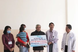 Đại diện bệnh viện trao bảng tượng trưng cho gia đình cháu K.. (Ảnh: TTXVN phát)