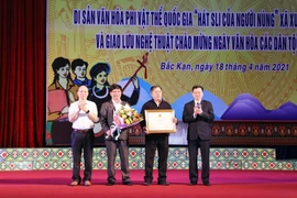Ông Phạm Duy Hưng, Phó Chủ tịch Ủy ban Nhân dân tỉnh Bắc Kạn (ngoài cùng bên phải) trao Bằng công nhận nhận di sản văn hóa phi vật thể quốc gia Hát Sli của người Nùng cho các nghệ nhân. (Ảnh: Vũ Hoàng Giang/TTXVN)