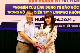 Giám đốc Bệnh viện Trung ương Huế tặng hoa cho bệnh nhân. (Ảnh: Tường Vi/TTXVN)