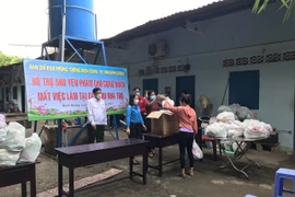 Ủy ban Mặt trận Tổ quốc Việt Nam tỉnh Bình Dương phối hợp với các sở, ngành triển khai chi hỗ trợ cho đối tượng công nhân đang ở trọ bị mất việc tại phường Phú Lợi, thành phố Thủ Dầu Một. (Ảnh: Huyền Trang/TTXVN)
