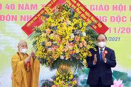 Chủ tịch nước Nguyễn Xuân Phúc tặng hoa chúc mừng Giáo hội Phật giáo Việt Nam. (Ảnh: Thống Nhất/TTXVN) 