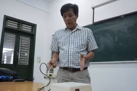 Thầy Nguyễn Văn Thịnh thuyết minh về nguyên lý hoạt động của máy nghiền bi trục đứng. (Ảnh: Văn Dũng/TTXVN)