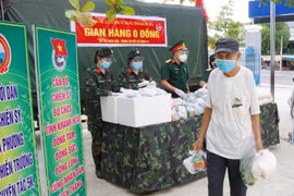 Người dân xã Phước Đồng, thành phố Nha Trang, tỉnh Khánh Hòa nhận hỗ trợ gạo và nhu yếu phẩm từ gian hàng 0 đồng do Bộ Chỉ huy Quân sự tỉnh Khánh Hòa tổ chức. (Nguồn: TTXVN) 