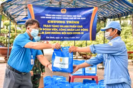 Liên đoàn Lao động Tân Bình trao quà hỗ trợ cho công nhân, người lao động có hoàn cảnh khó khăn bị ảnh hưởng bởi dịch COVID-19. (Ảnh: Thanh Vũ/TTXVN)