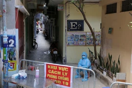 Phong tỏa, cách ly y tế khu nhà E2, 128C Đại La, phường Đồng Tâm (Hà Nội), nơi ở của cháu bé sinh năm 2020 có kết quả dương tính với SARS-CoV-2. (Nguồn: TTXVN) 