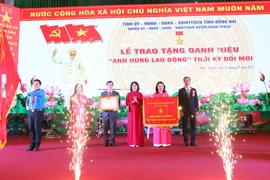 Phó Chủ tịch nước Đặng Thị Ngọc Thịnh trao danh hiệu Anh hùng lao động thời kỳ đổi mới cho Đảng bộ, chính quyền và nhân dân huyện Nhơn Trạch. (Ảnh: Công Phong/TTXVN)