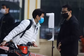 Học sinh trường THPT Việt Đức được đo thân nhiệt và khử khuẩn tại khu vực cổng trường trước khi lên lớp. (Ảnh: Hoài Nam/Vietnam+) 