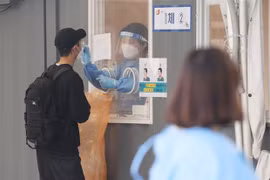 Nhân viên y tế lấy mẫu xét nghiệm COVID-19 cho người dân tại Seoul, Hàn Quốc. (Ảnh: YONHAP/TTXVN) 