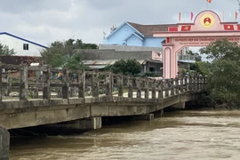 Hai nhịp cầu Đại Hàn bị sụt nghiêng, hiện tại nước lũ dưới chân cầu vẫn đang chảy xiết. (Ảnh: Tường Quân/TTXVN)