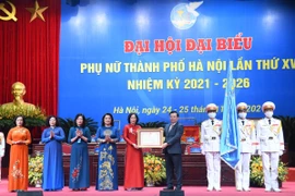 Thừa ủy quyền lãnh đạo Đảng, Nhà nước, Bí thư Thành ủy Hà Nội Đinh Tiến Dũng trao Huân chương Lao động hạng Nhất cho Hội Liên hiệp phụ nữ thành phố Hà Nội. (Ảnh: TTXVN phát)