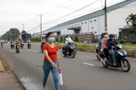 Công nhân tới nhà máy làm việc tại Khu công nghiệp Sóng Thần I, thành phố Dĩ An. (Ảnh: TTXVN phát)