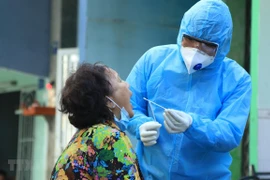 Nhân viên y tế lấy mẫu xét nghiệm người dân trong khu vực Lô E, Lò Gốm (phường 7, quận 6). Ảnh minh họa. (Ảnh: Đinh Hằng/TTXVN)