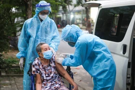 Đội lưu động y tế đến tận nhà để tiêm vaccine phòng COVID-19 cho cho người lớn tuổi có bệnh lý nền tại quận Sơn Trà (Đà Nẵng). (Ảnh: Trần Lê Lâm/TTXVN) 