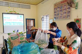 Các tình nguyên viên của mô hình Đi chợ giúp dân đang chuẩn bị các hàng hóa thiết yếu phân bổ đến các hộ dân. (Ảnh: Chanh Đa/TTXVN)