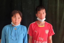 Hai đối tượng Vàng Seo Vư và Vàng Thị Mỷ tại đồn biên phòng Si Ma Cai. (Ảnh: TTXVN phát)