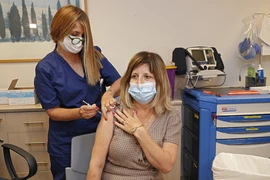 Nhân viên y tế tiêm vaccine ngừa COVID-19 cho người dân tại Tel Aviv, Israel. (Ảnh: AFP/TTXVN)