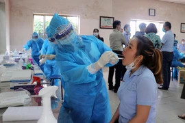 Nhân viên y tế lấy mẫu xét nghiệm cho công nhân làm việc tại các khu công nghiệp. (Ảnh: TTXVN phát) 