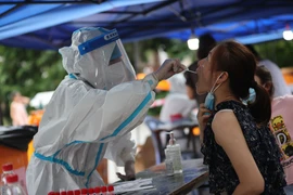 Nhân viên y tế lấy mẫu xét nghiệm COVID-19 cho người dân tại Phúc Kiến, Trung Quốc ngày 30/7/2021. (Ảnh: THX/TTXVN)