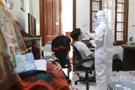 Nhân viên y tế quận Hoàn Kiếm đến lấy mẫu tại hộ gia đình có người tự cách ly liên quan đến trường hợp mắc COVID-19 (ảnh chụp 31/5/2021). (Ảnh: Minh Quyết/TTXVN) 